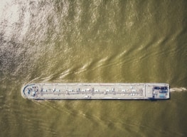 A cargo vessel viewed from above, with digital survey data overlay on screen.