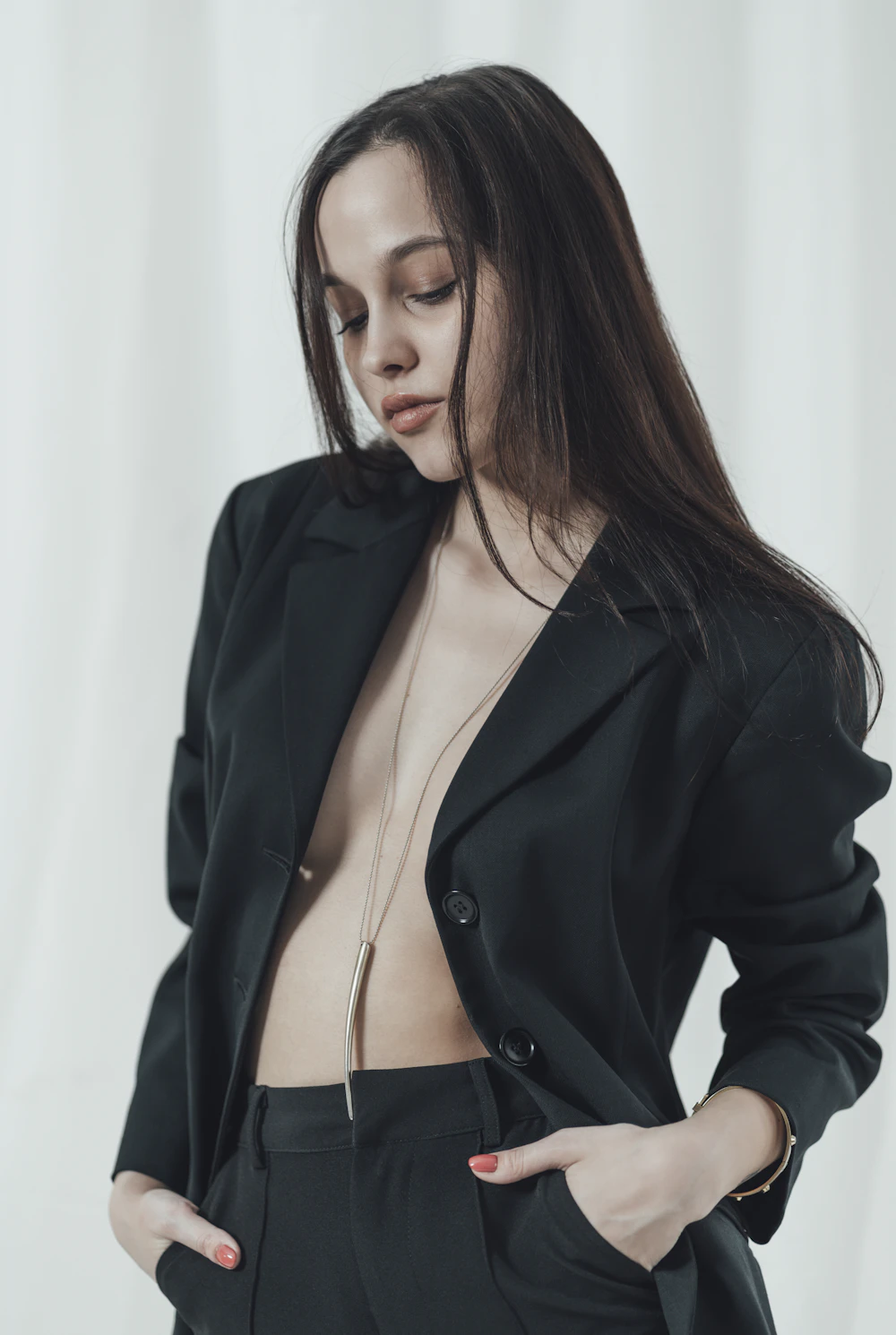 Open black tailored blazer with pendant necklace