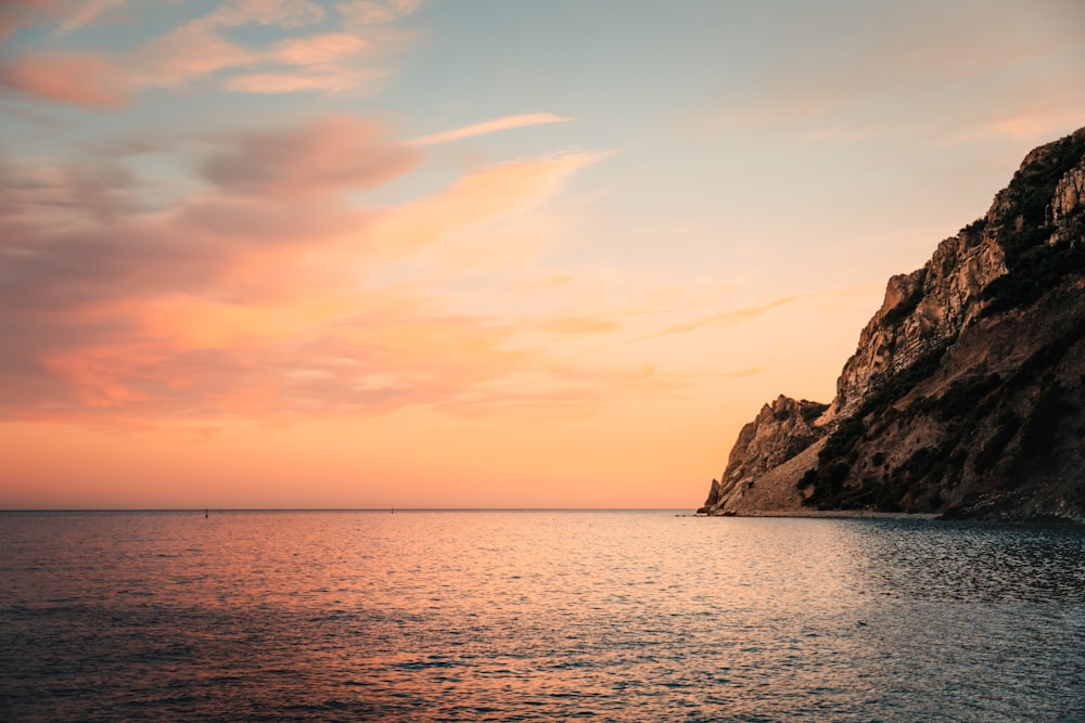 a large body of water with a mountain in the background