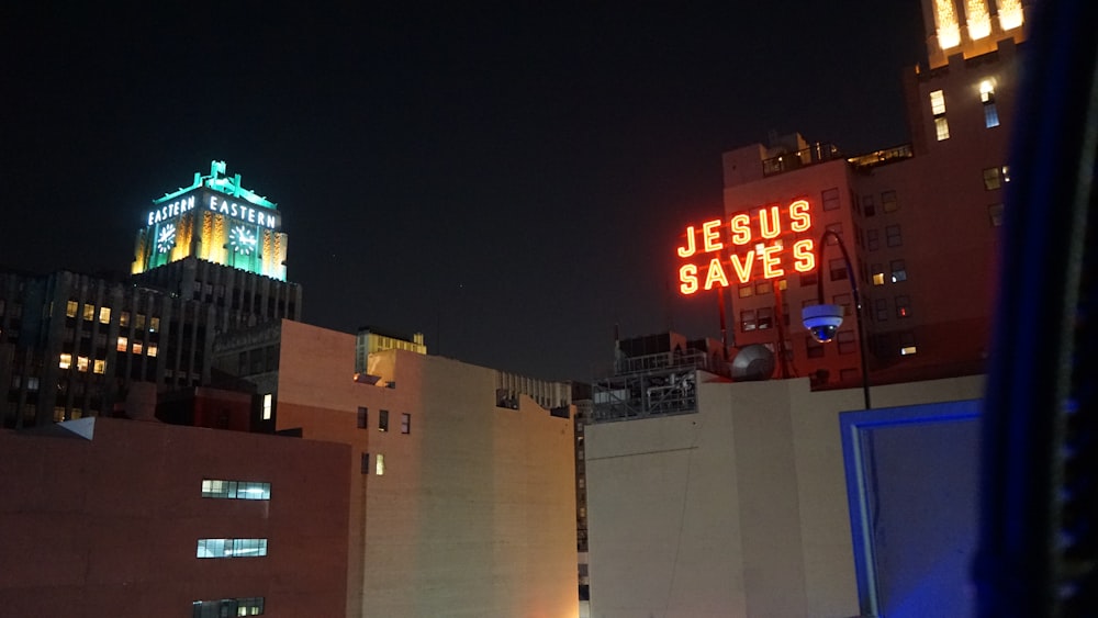 a building with a neon jesus saves sign on top of it