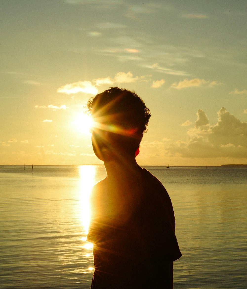 a man standing in front of a body of water