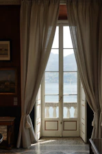 A sunlit, elegant suite with plush furnishings overlooking the Nile River at sunset.