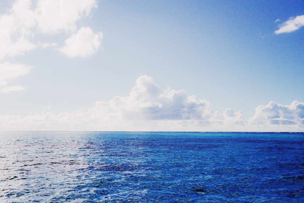 a large body of water with clouds in the sky