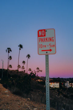 Close-up of a pastel-colored no parking sign fading into a colorful Easter background.