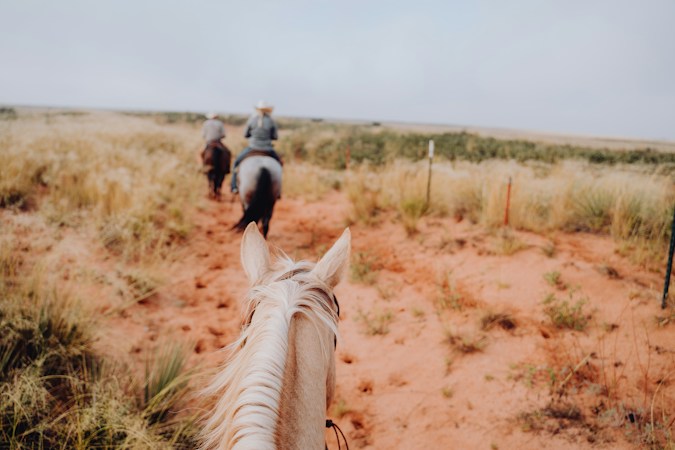 Two riders on horseback on a dirt road, the kind of rural horse-property lifestyle many northwest Las Vegas county island residents want to protect