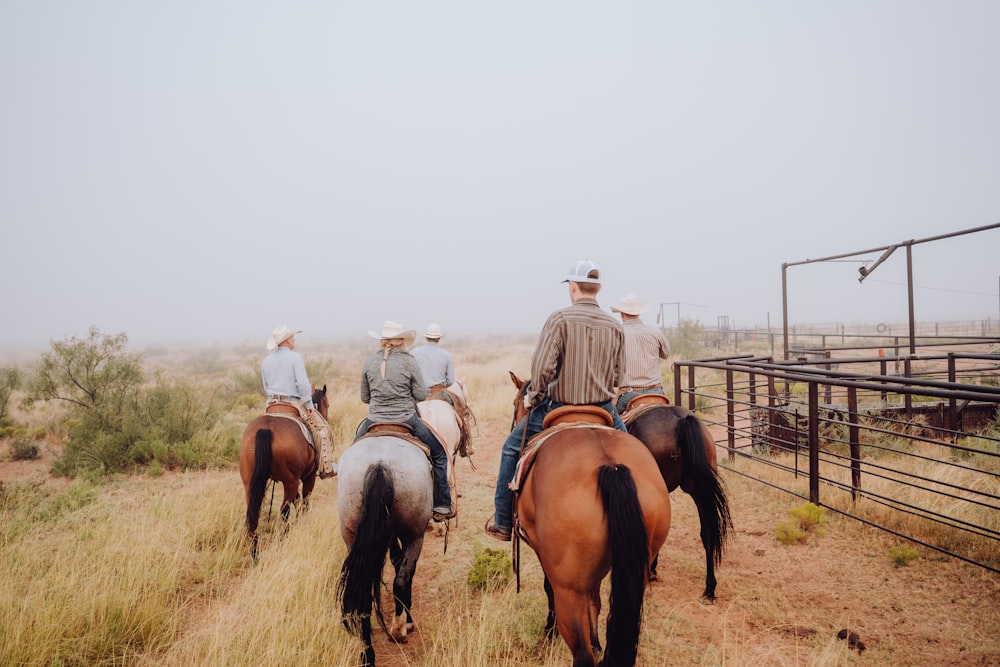 a group of people riding on the backs of horses