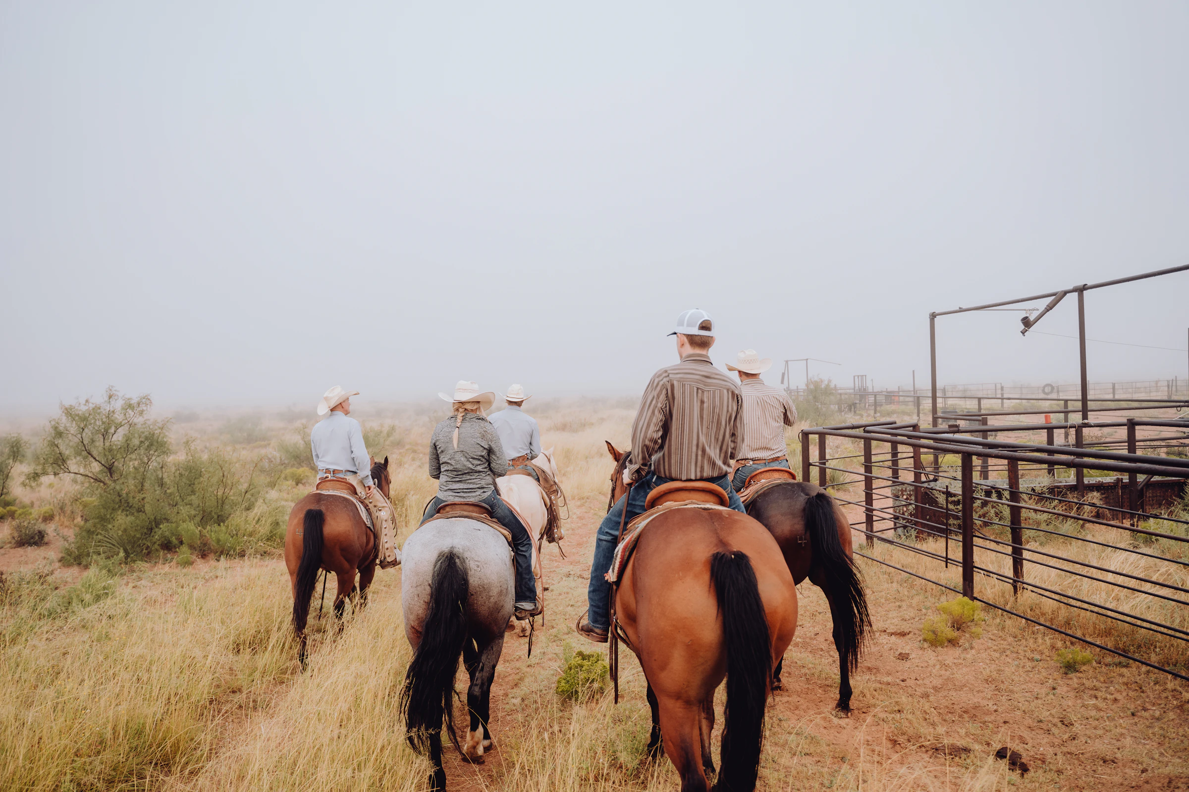 A group of riders setting off together from a ranch
