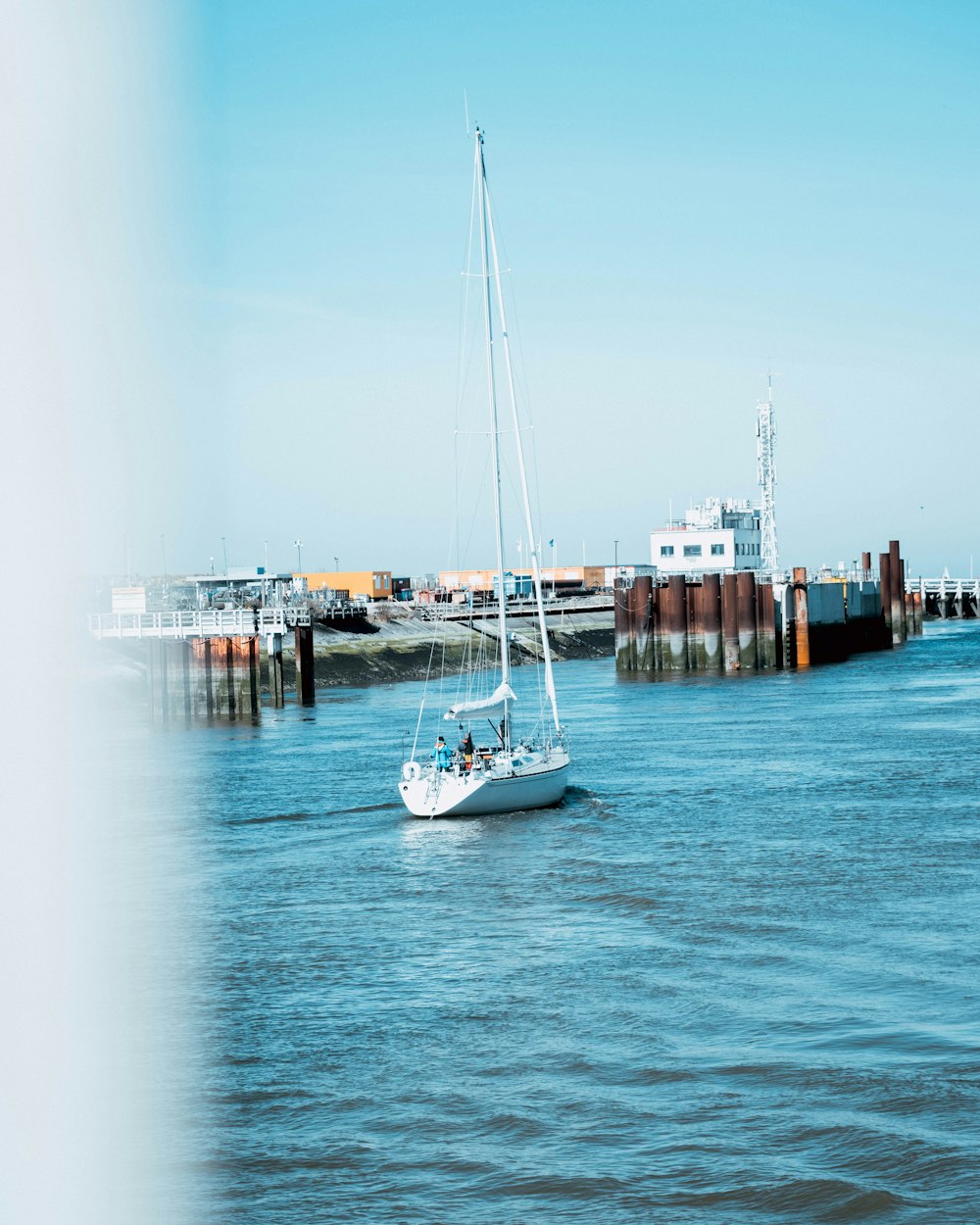 a sailboat is in the water near a dock