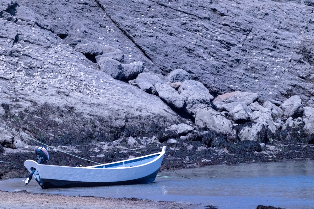 a small boat sitting on top of a sandy beach