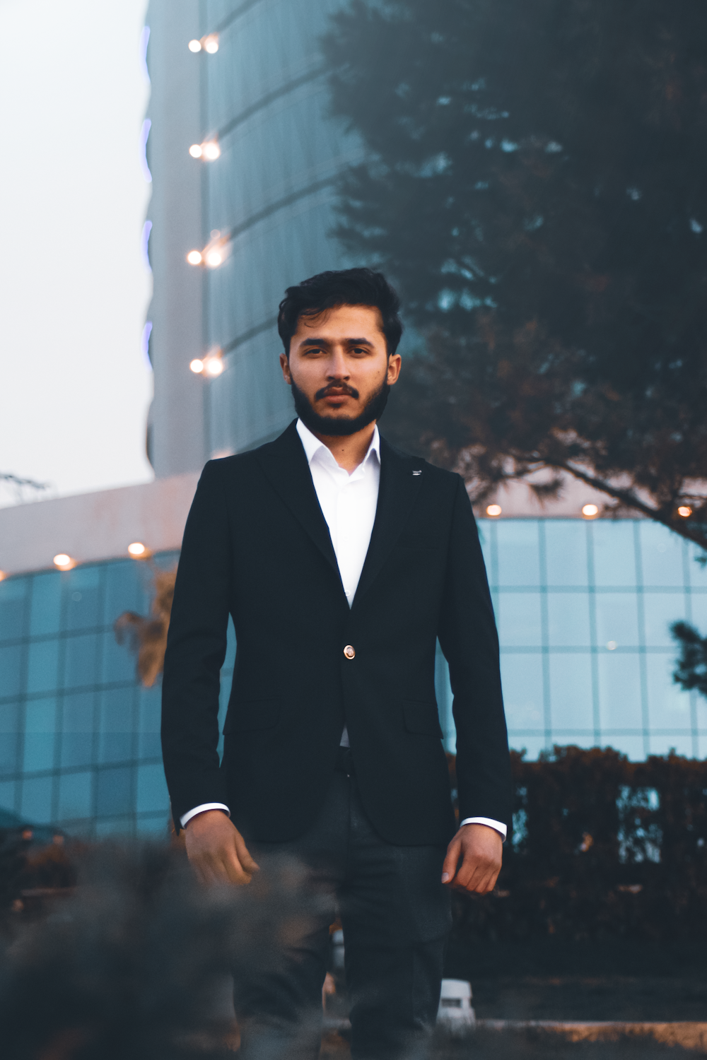 a man in a suit standing in front of a building