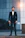 a man in a suit standing in front of a building