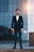 a man in a suit standing in front of a building