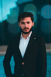a man in a suit standing in front of a building