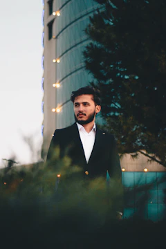 A senior legal expert in a dark charcoal pinstripe suit stands confidently in a futuristic glass boardroom with a glowing city skyline at golden hour behind him.