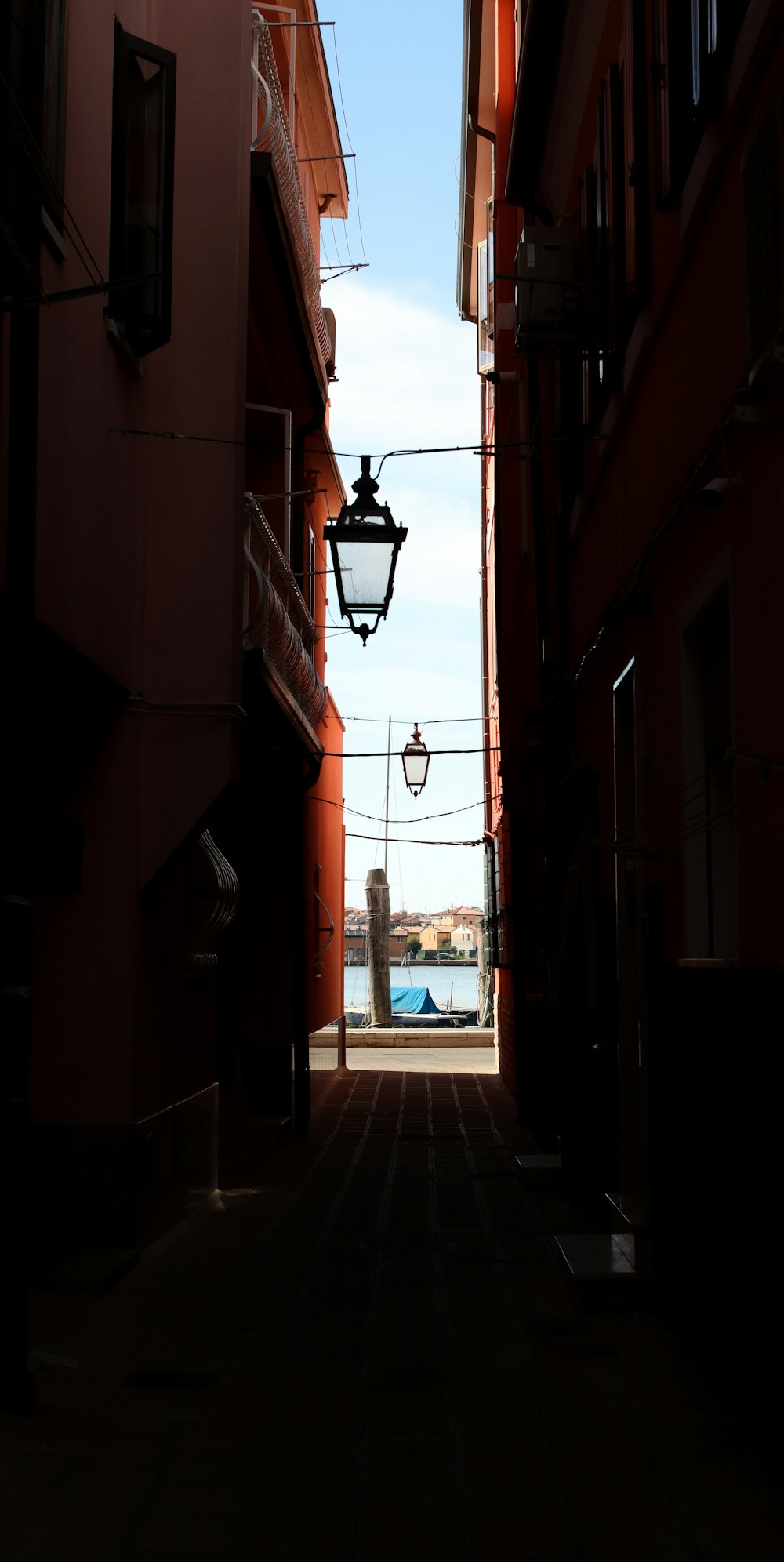 a narrow alley way with a street light in the middle