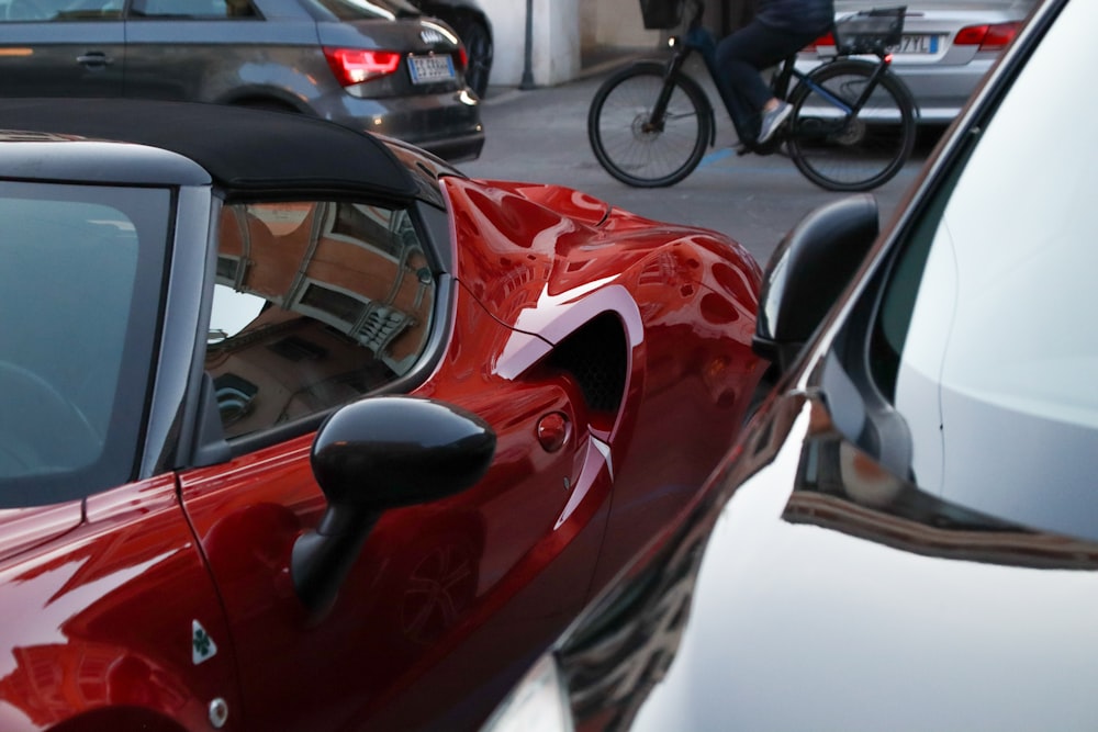 a close up of a red sports car parked in a parking lot