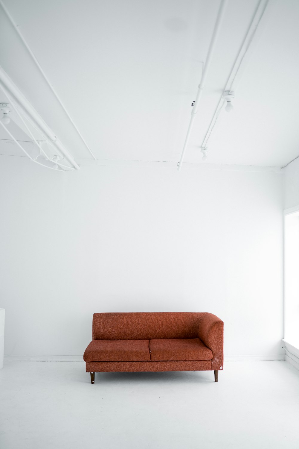 a red couch sitting in a white room