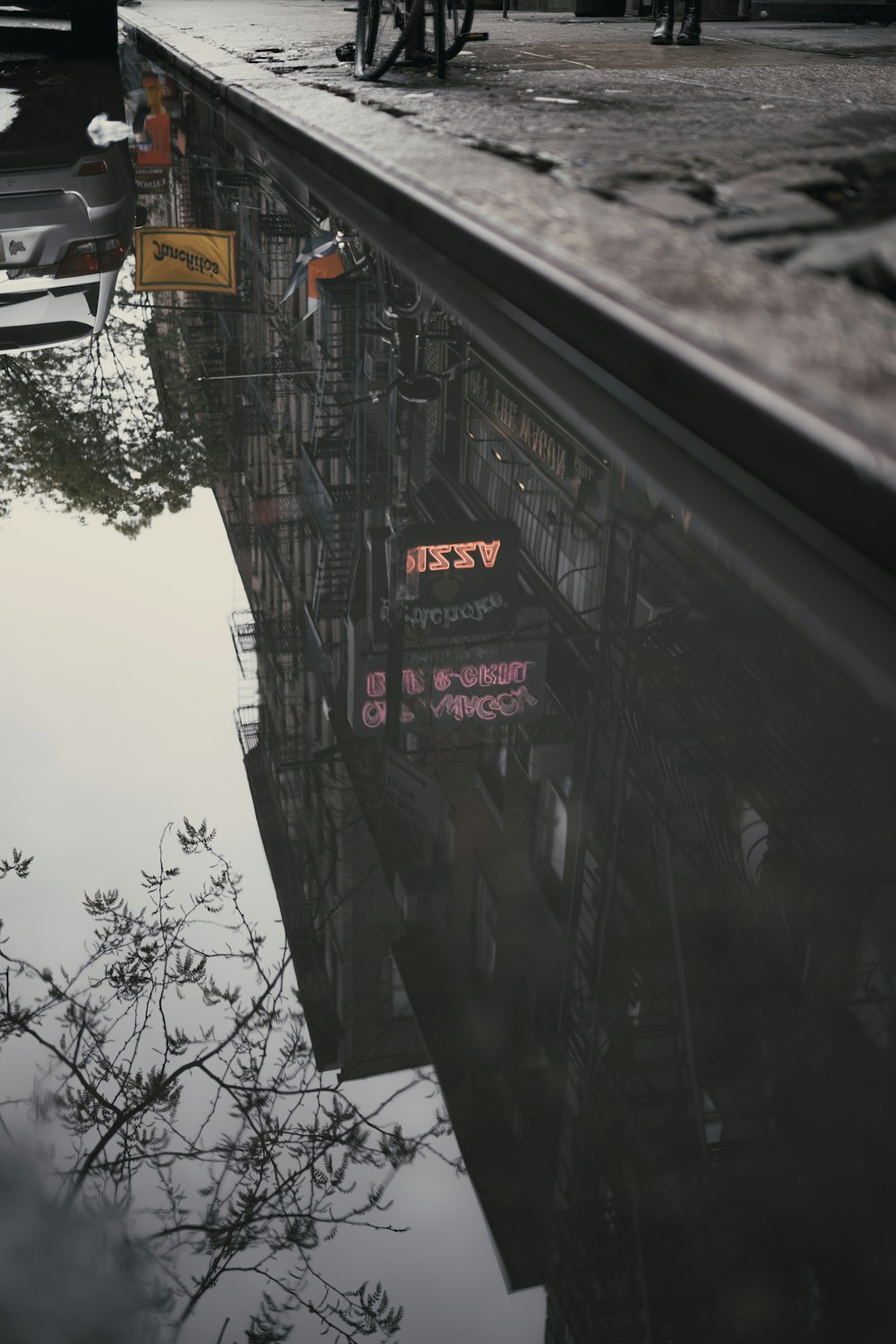 a reflection of a building in a puddle of water