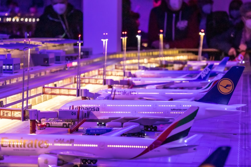 a row of model airplanes sitting on top of a runway