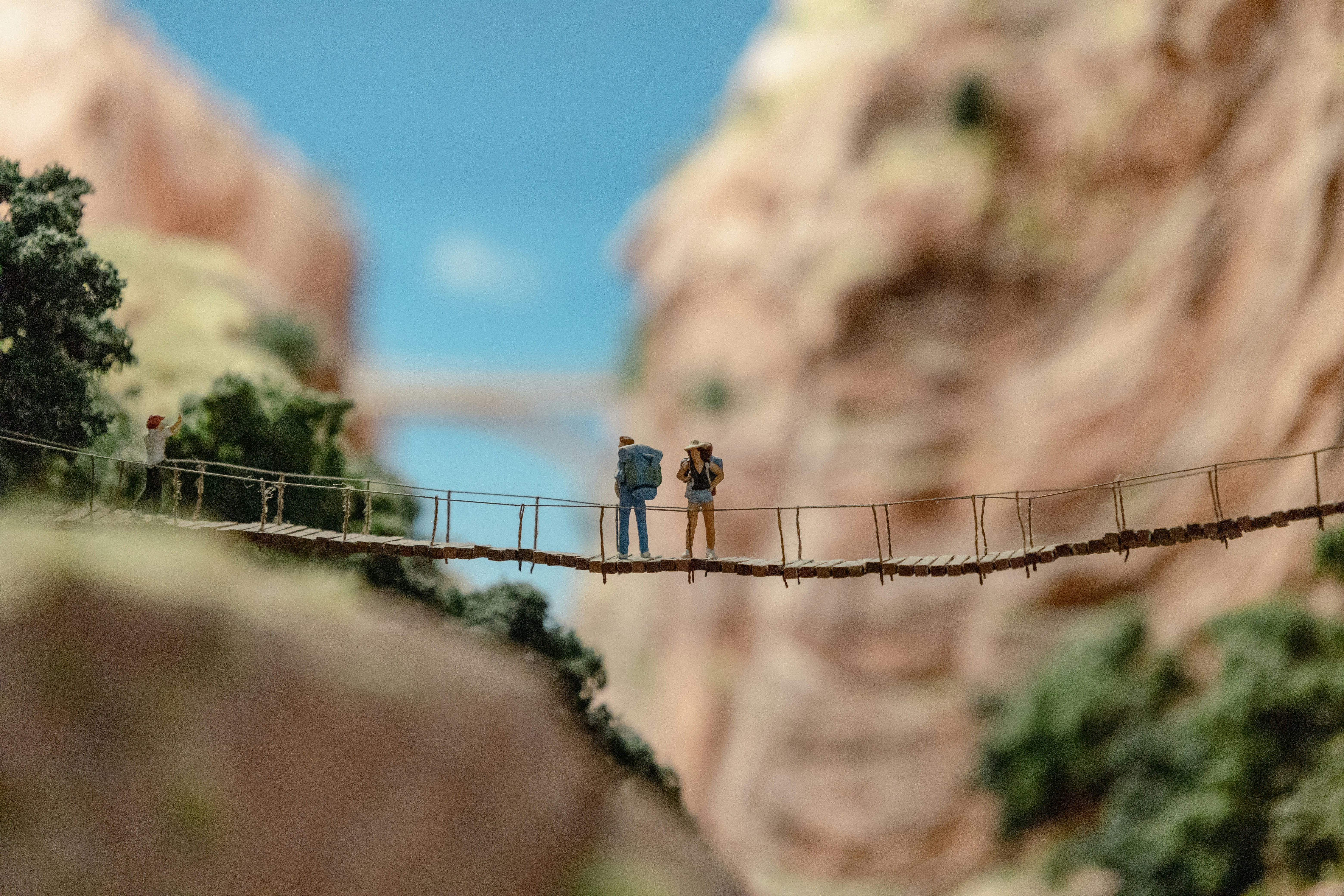 a couple of people walking across a wooden bridge