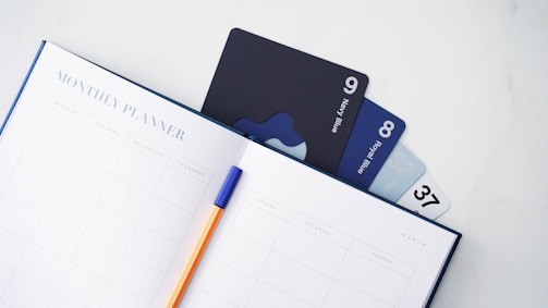 a notebook with a pen and credit cards