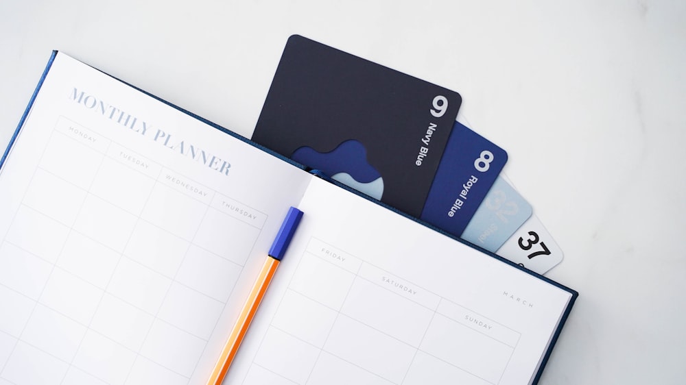 a notebook with a pen and credit cards
