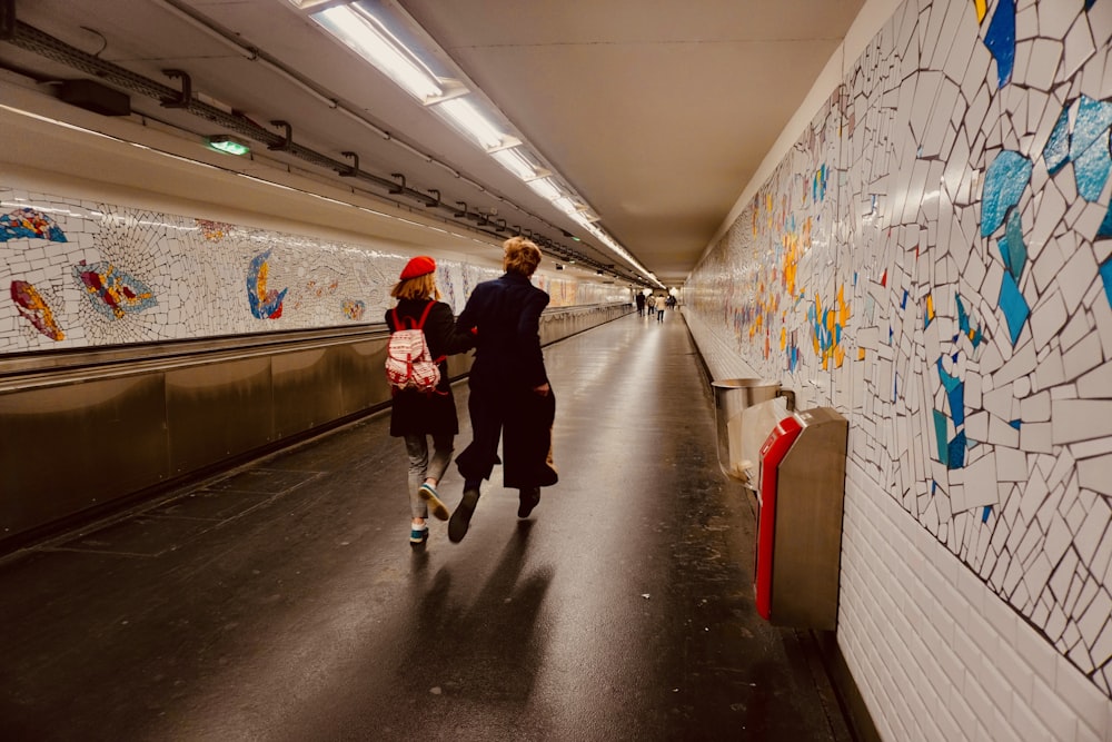 a man and a woman walking down a subway