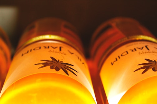 Close-up of golden, cold-pressed organic oil bottles glistening in natural sunlight.