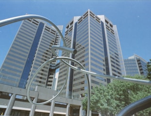 a metal sculpture in front of a tall building