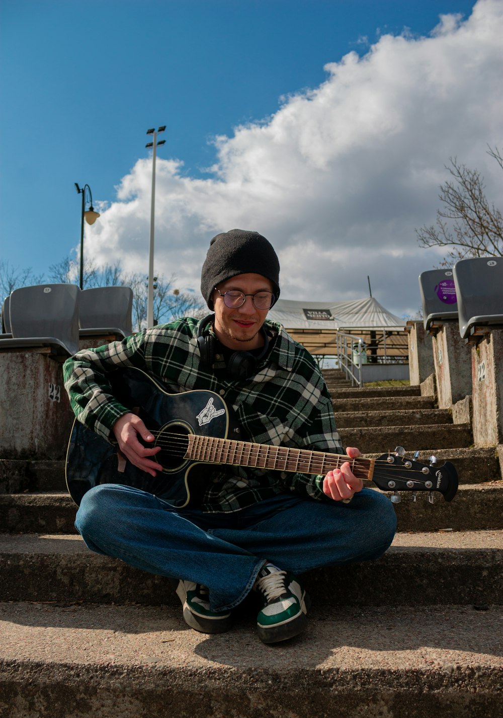 a man sitting on steps playing a guitar