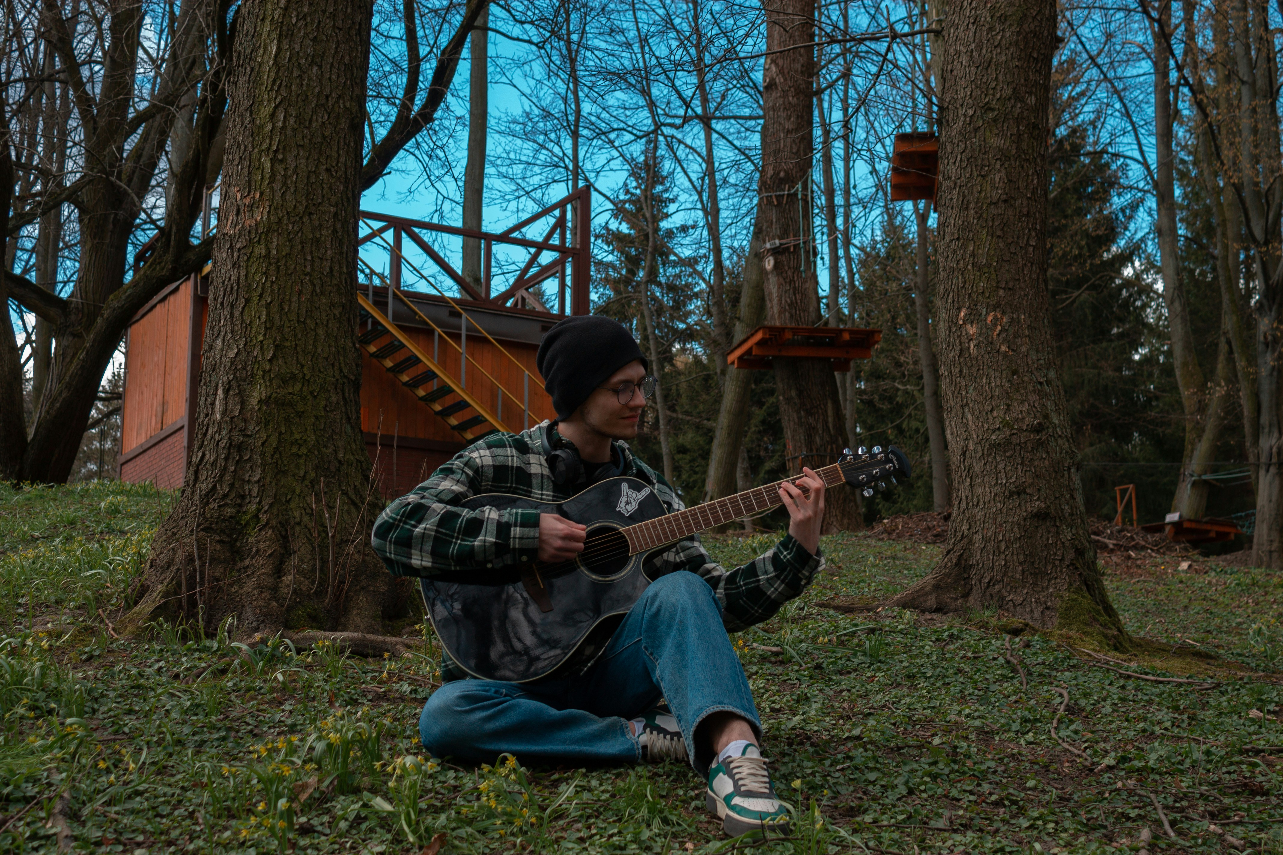 a man sitting on the ground playing a guitar