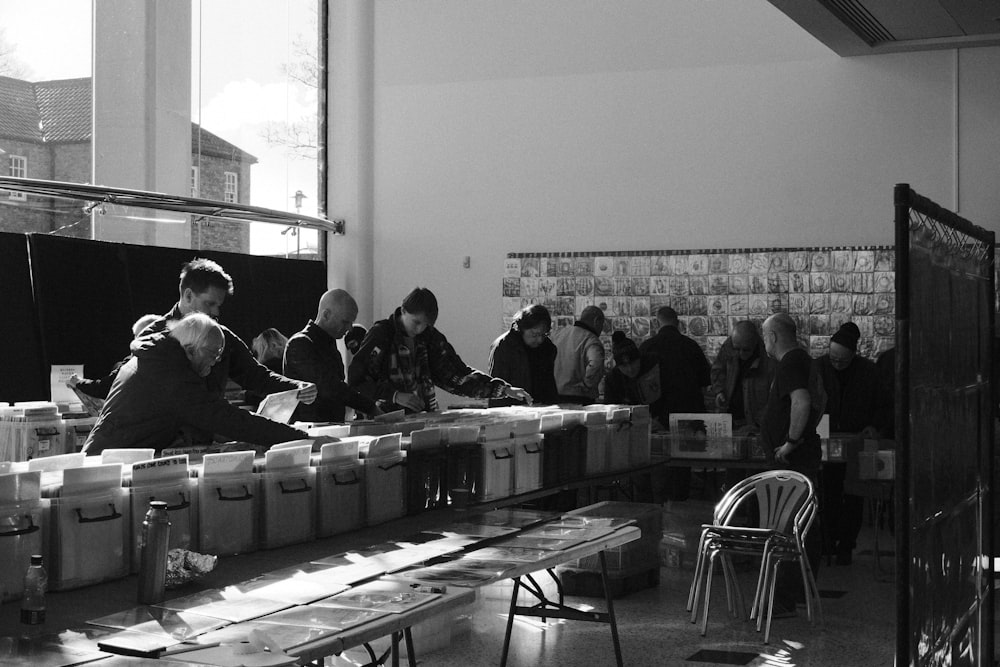 a group of people standing around a table with boxes on it