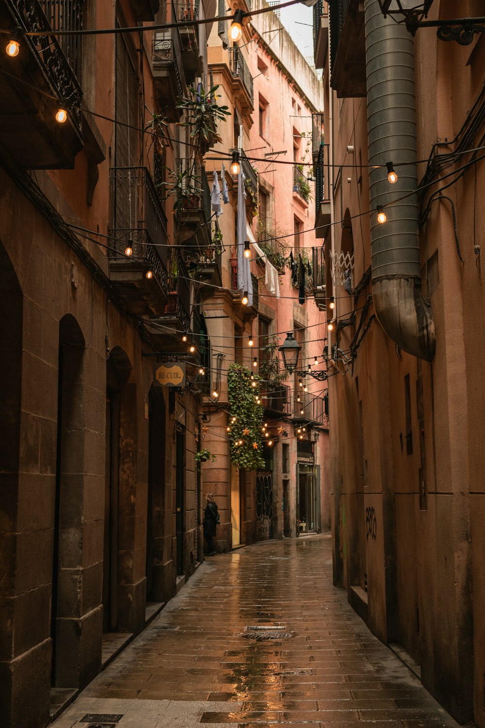 a narrow alleyway with a few people walking down it