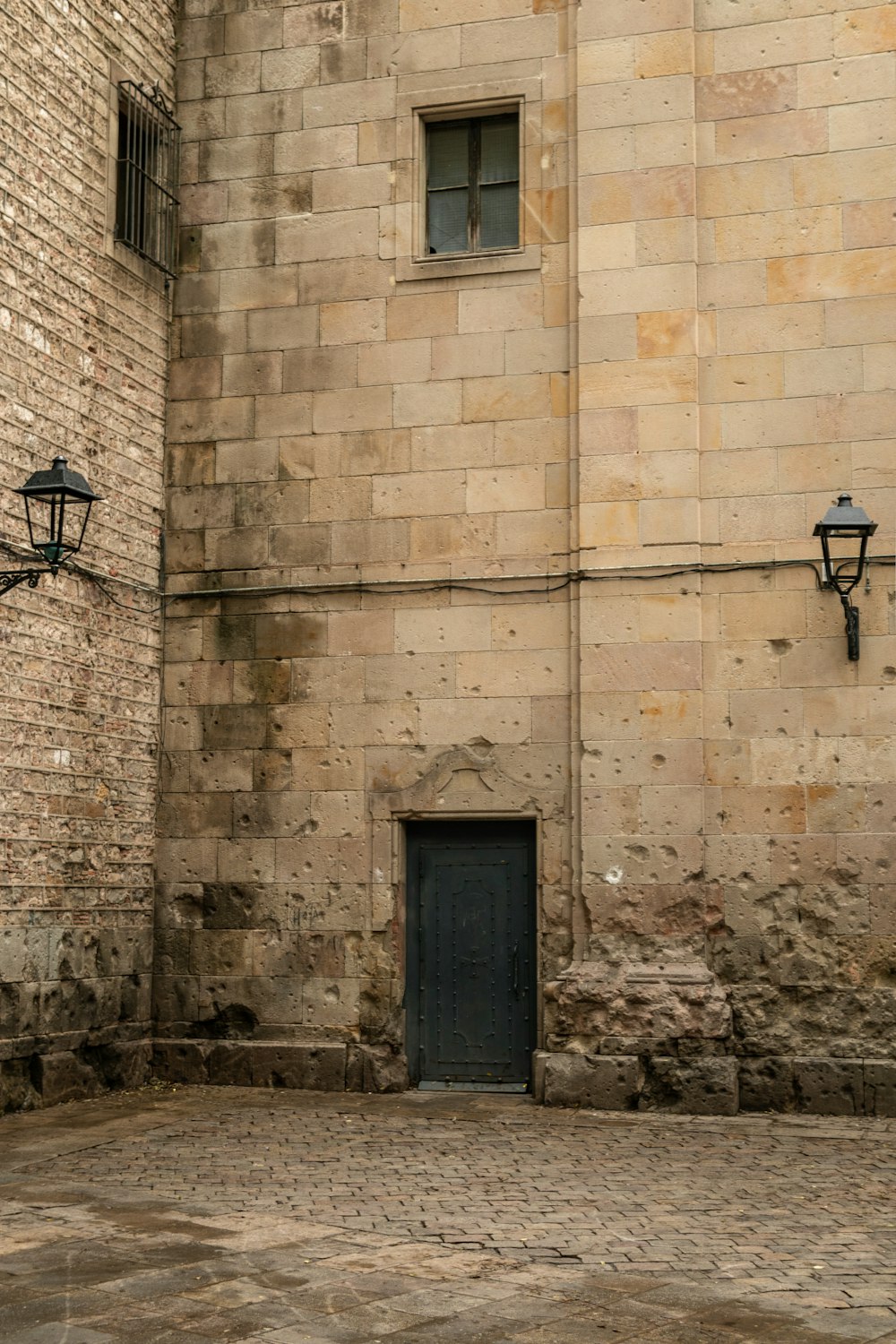 a brick building with a black door and two street lights