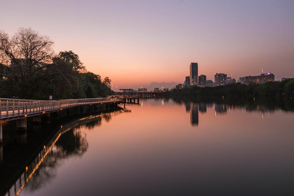 a bridge over a body of water with a city in the background