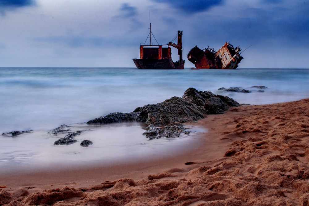 Un barco sentado en la cima de una playa de arena junto al océano