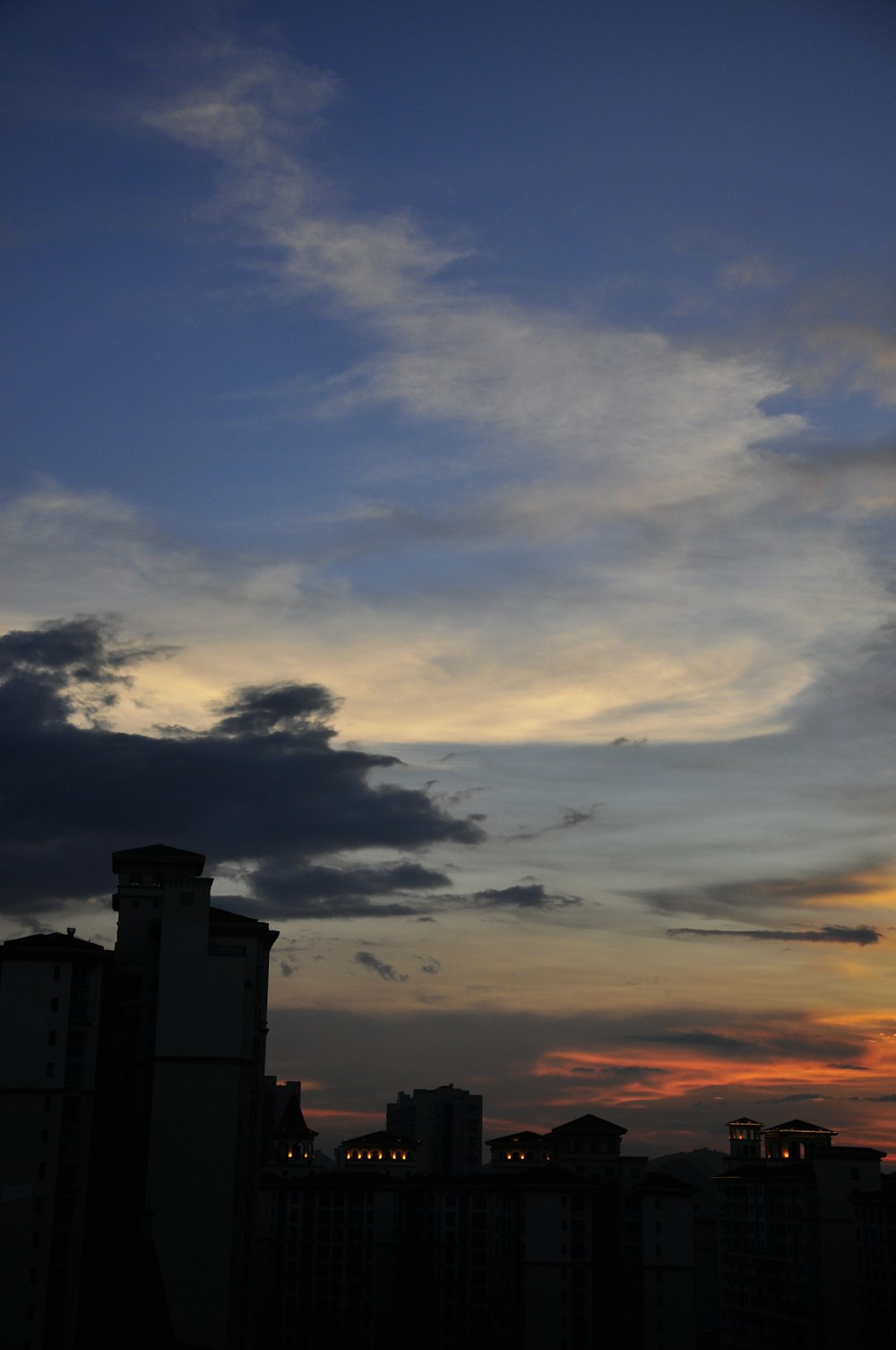 a city skyline at sunset with clouds in the sky