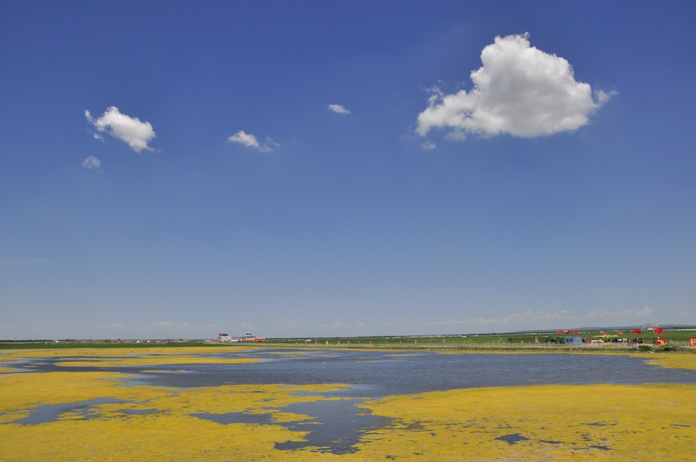 a large body of water sitting under a cloudy blue sky