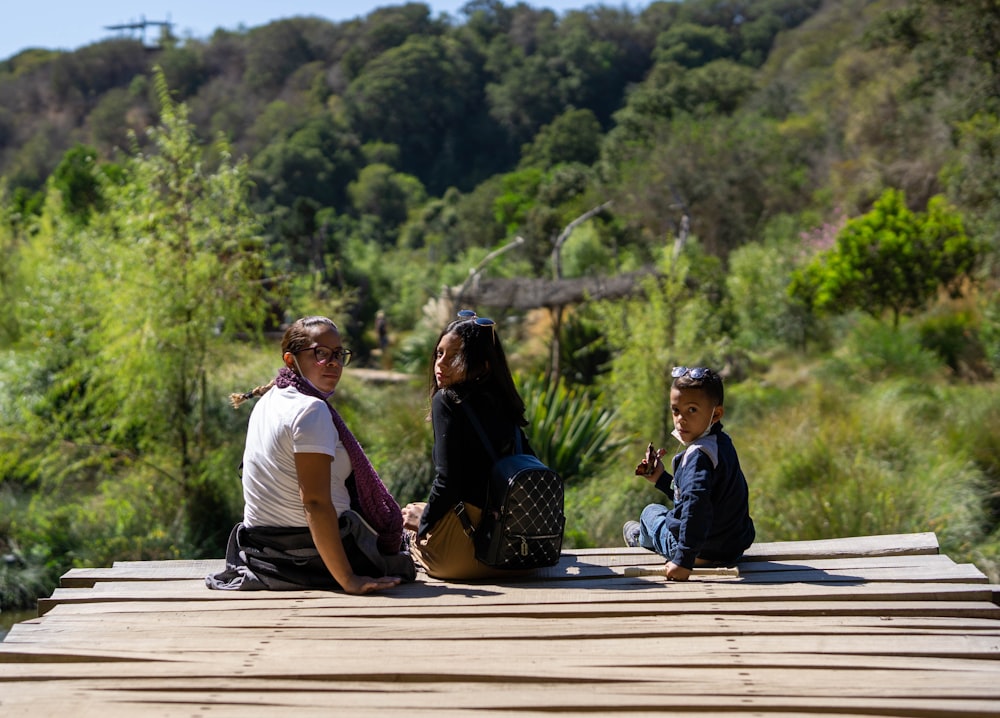 a group of people sitting on top of a wooden platform