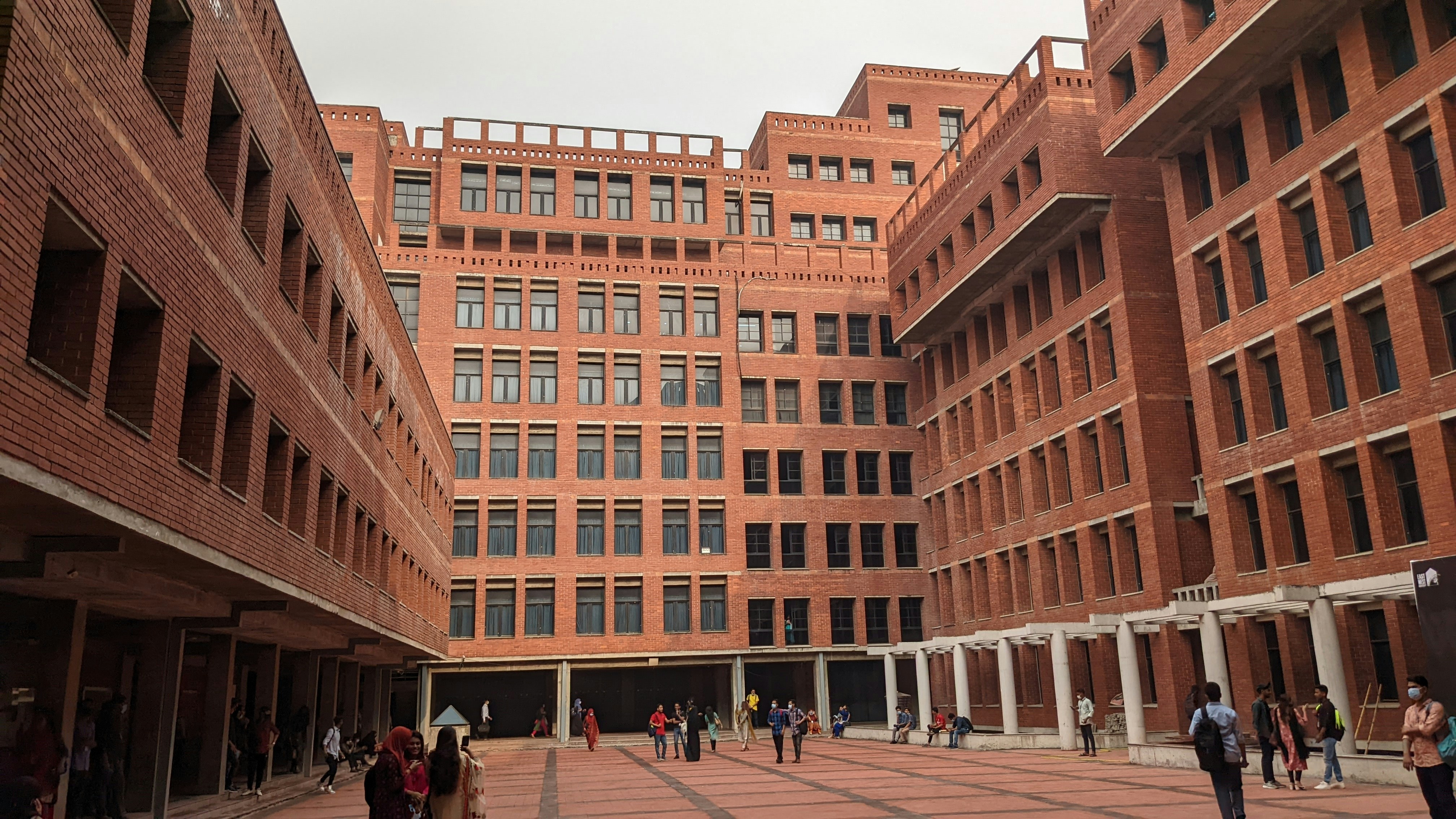 Contemporary university campus with modern architecture and students on open courtyard