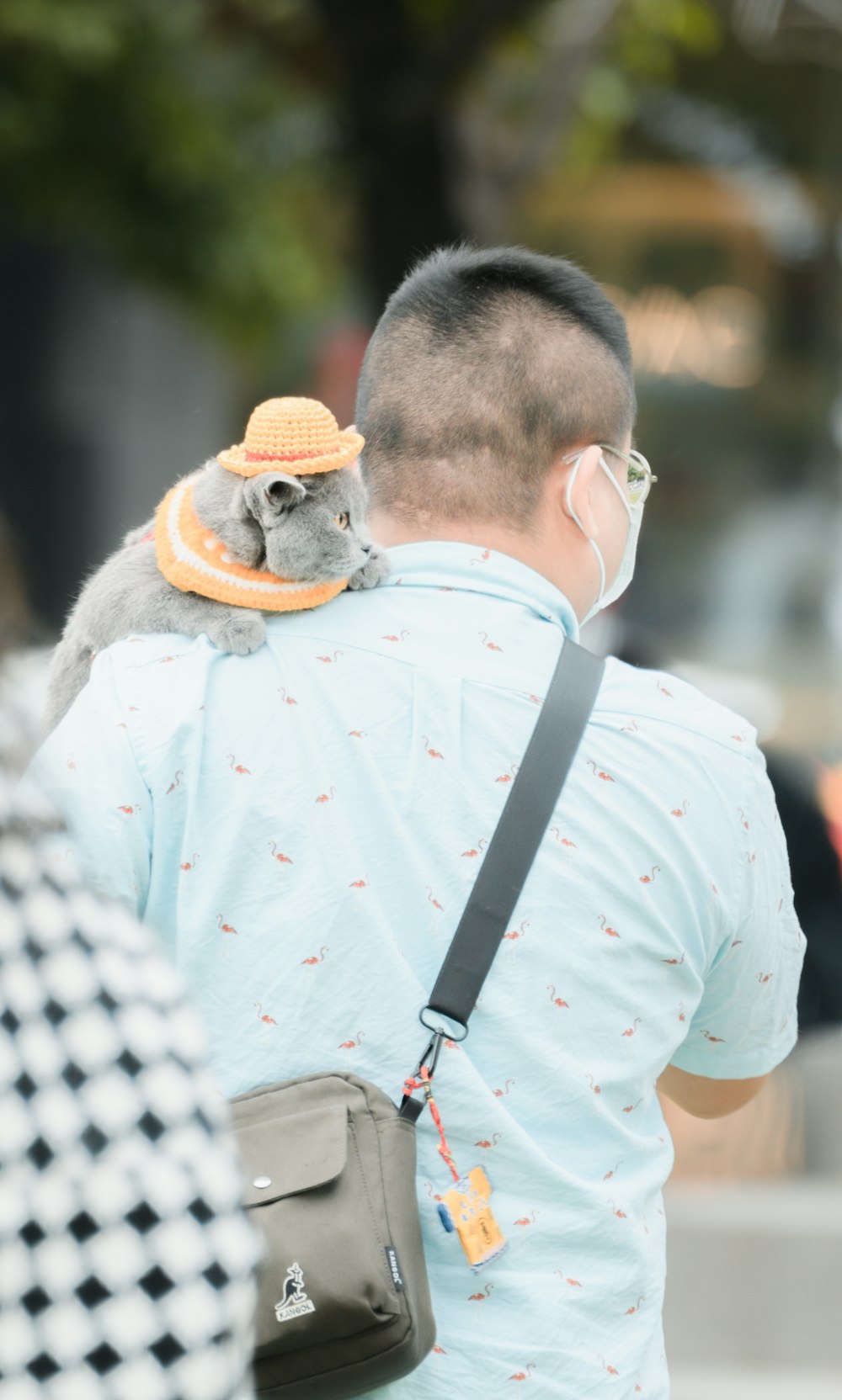 a man wearing a face mask holding a small animal