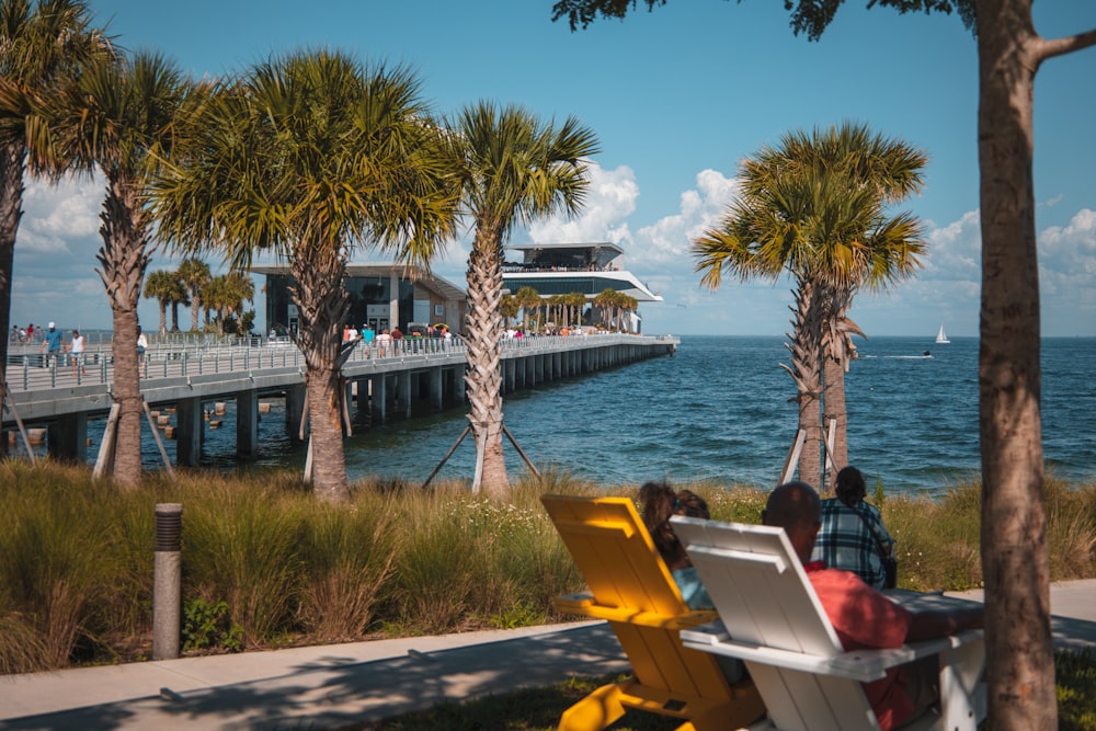 a man sitting on a bench next to a body of water