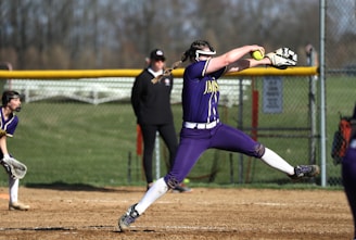 a softball player throwing a ball on a field
