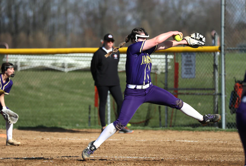 Softball pitcher throwing on the field