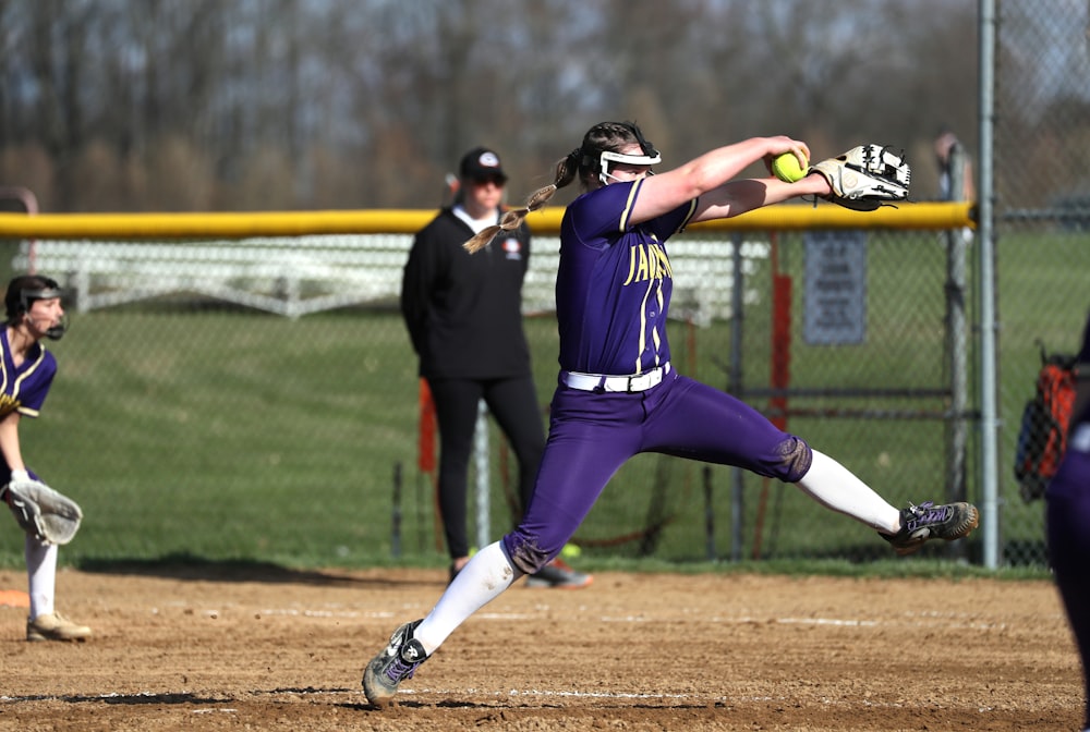 a softball player throwing a ball on a field