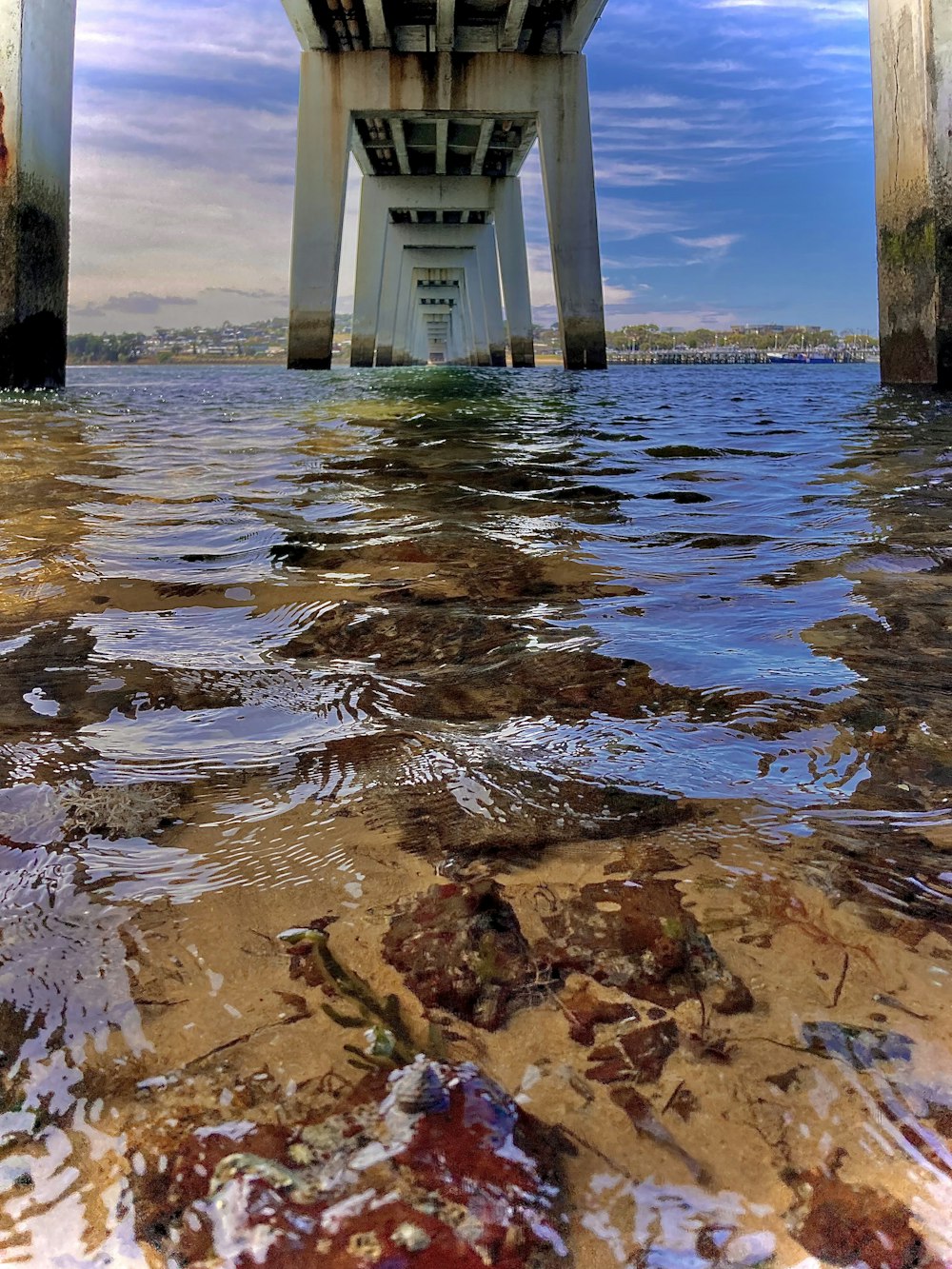 the underside of a bridge over a body of water