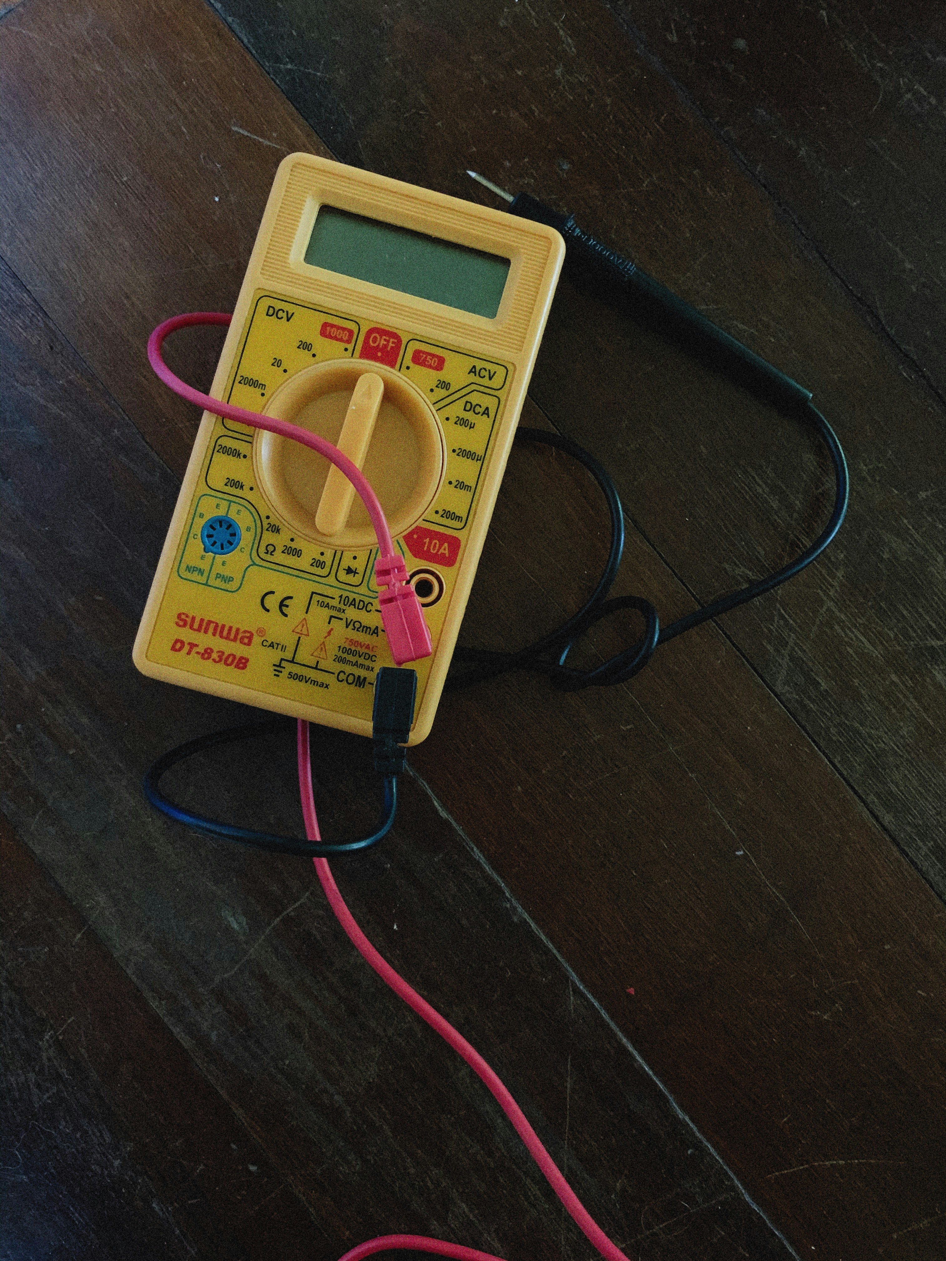 a multimeter sitting on top of a wooden floor