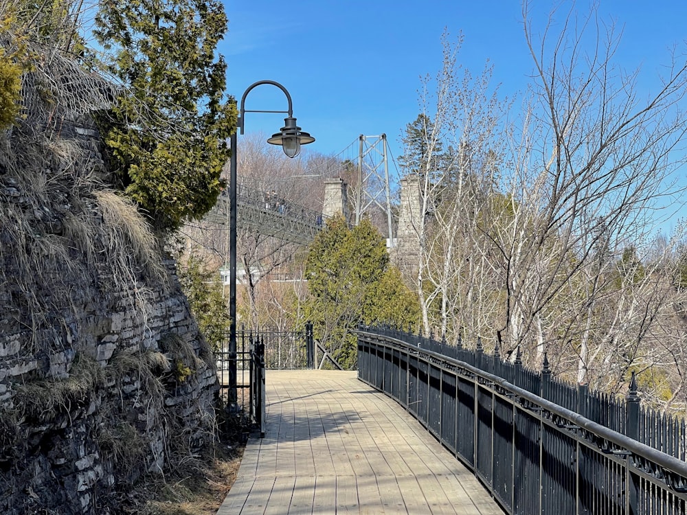 A walkway with a lamp post next to a stone wall photo – Free  Chutes-montmorency Image on Unsplash