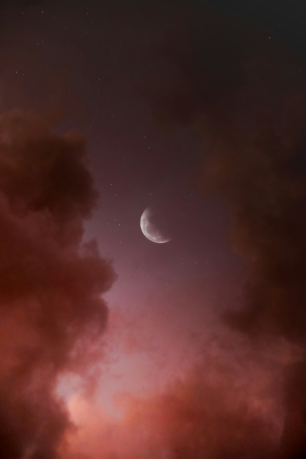 the moon is seen through the clouds in the night sky