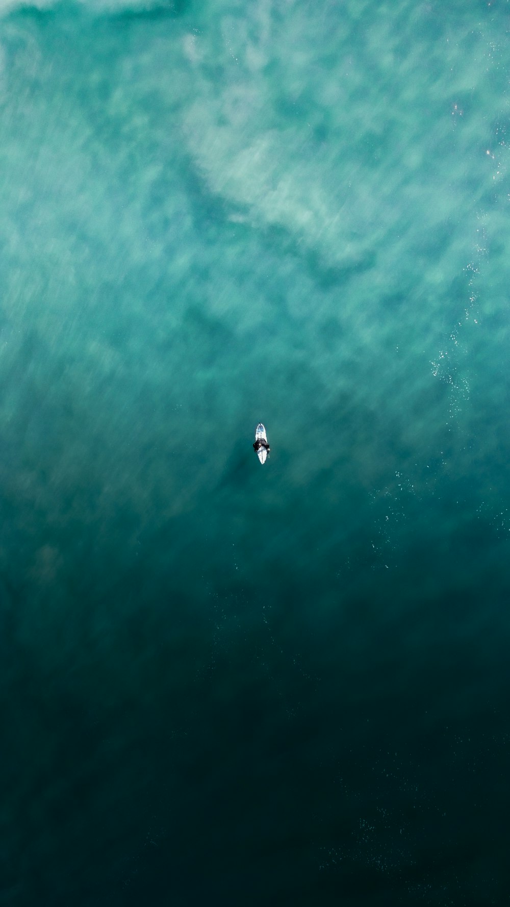 an aerial view of a surfer riding a wave